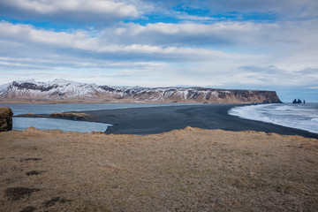 Iceland Vik south coast panorama with mountains and brown meadow in winter