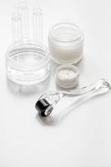 concept cosmetologist desktop with mezoroller - mesotherapy on white background