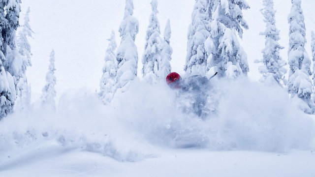 Male snowboarder making powder turn in the backcountry