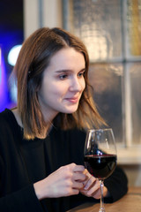 Portrait of elegant charming young glamour woman in restaurant with glass of red wine/Closeup portrait of a pretty girl with a glass