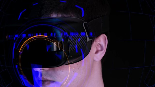 Close-up shot of a young man wearing VR Headset playing virtual reality games. Futuristic hud around him.