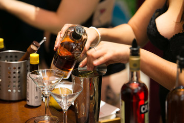 Caucasian woman makes mixed drinks at a fancy party