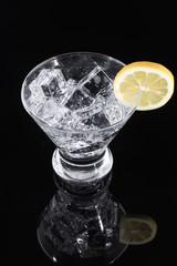 Sparkling beverage in a martini glass with a lemon slice on a bl