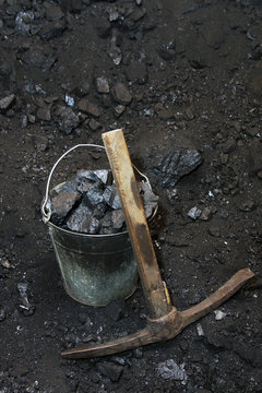 Retro coal mining. Pickaxe and the bucket full of lumps of coal in mine