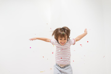 Cute little boy celebrating for party on white wall copy space