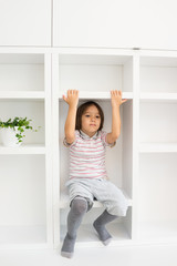 Fototapeta na wymiar Kid in shelves at home