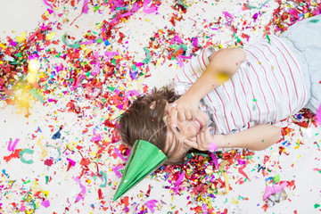 Obraz na płótnie Canvas Young boy blows out confetti, isolated on white background