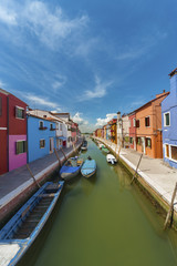 Burano island canal, colorful houses and boats, Venice, Italy.
