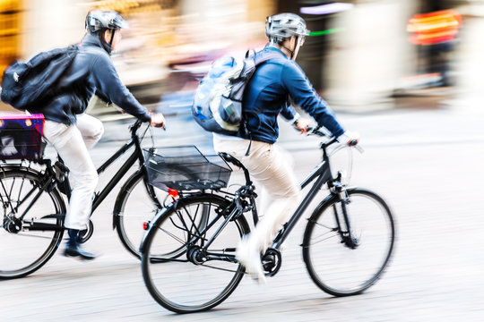 Fototapeta bicycle riders in city traffic in motion blur