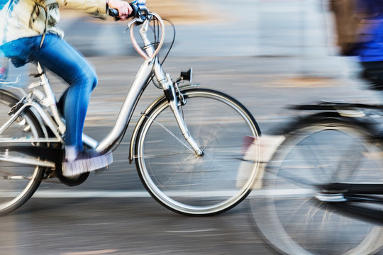 Fototapeta bicycle riders in city traffic in motion blur