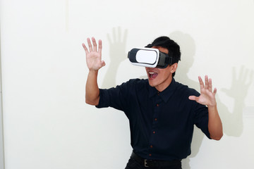 Excited man experiencing virtual reality via VR headset and touching something with his hands.