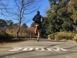 Rear view of runner on running course in park