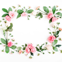 Round frame made of pink and beige roses, green leaves, branches on white background. Flat lay, top view. Valentine's background