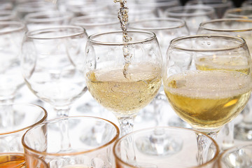 White wine pouring into wine glass, closeup
