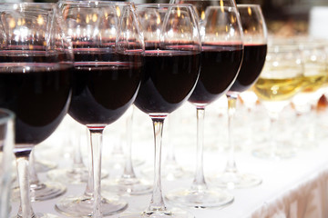 Glasses of red wine on white table closeup