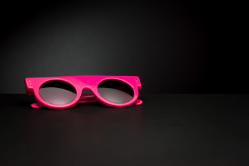 Stylish sunglasses for summer on black background