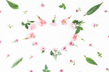 Flowers composition. Heart symbol made of pink flowers and leaves. Top view, flat lay