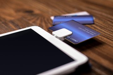 Credit card payment on a swipe or chip reader app on a tablet used by small or online businesses.  The electronic device is used as a modern cash register or for banking.