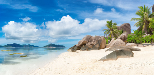 Tropical beach at Seychelles on La Digue island and Praslin island on the horizon. Panoramic image.