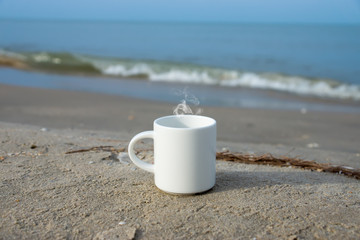 Fototapeta na wymiar White coffee mug on the beach.