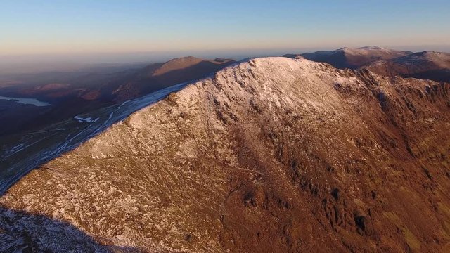 Panning aerial shot of Crib Goch, covered in new winter snow.