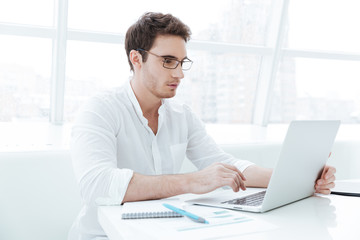 Concentrated young man using laptop computer.