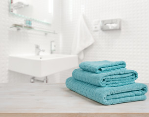 Obraz na płótnie Canvas Turquoise spa towels pile on wood over blurred bathroom background