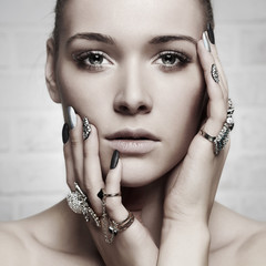 Obraz premium beauty face.woman's hands with jewelry rings.fashion girl make-up and manicure