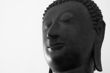 Traditional Buddha head against a white background with copy space. 