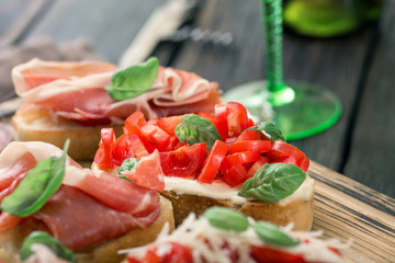 Variety small sandwiches with prosciutto, tomatoes, fresh basil