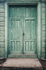Wall murals The street door of the old house with a porch painted in green color. Paint became old from time