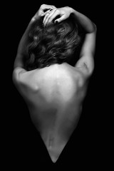 beautiful back of young woman in a black sexy dress.Girl with curly healthy hair
