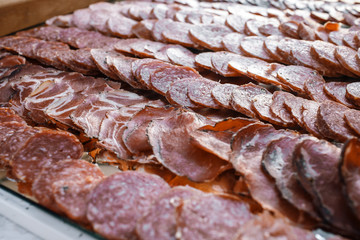 Tasty salted meat lies sliced on table