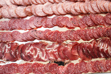 Tasty salted meat lies sliced on table