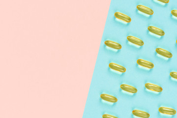 Fish oil meds making pattern on pink and blue paper