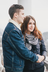 Young couple in love posing outdoors, hug and kiss