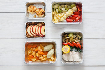 Healthy food take away in boxes, top view at wood