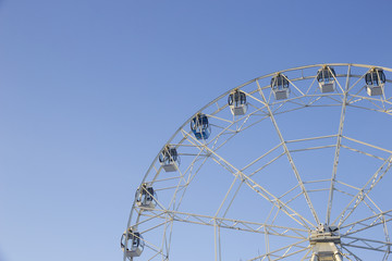 Half Ferris wheel against the blue sky