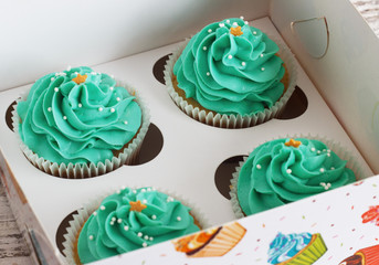 Chocolate cupcake with mousse cream icing on grunge white wooden background copy space