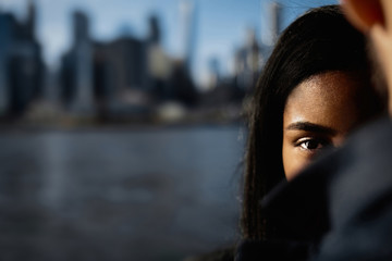Look over man's shoulder at woman standing before NY cityscape