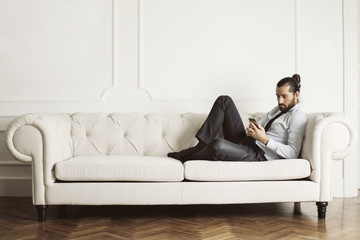 Man sitting of huge white sofa 