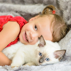 Fototapeta na wymiar Cute girl hugging kitten 
