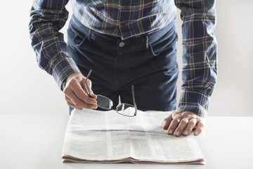 Man reading newspaper on table