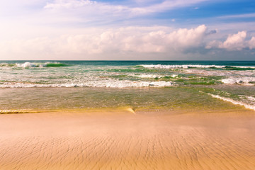 Fototapeta na wymiar Sandy beach and turquoise ocean waves.