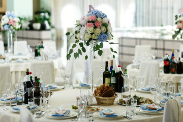 Bouquet of blue, pink and white roses stands on tall glass vase