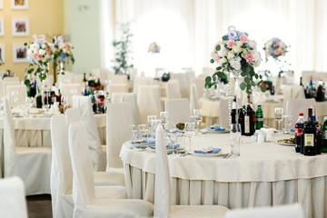 Bouquet of blue, pink and white roses stands on tall glass vase