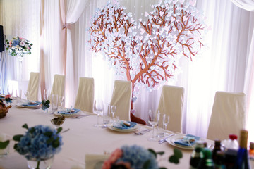 Gorgeous tree with leaves of hearts stands behind long dinner ta