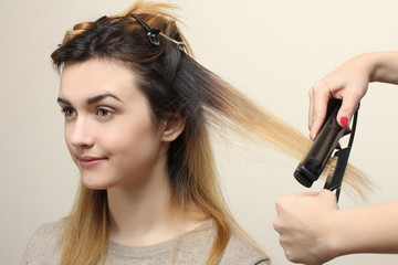 Fototapeta premium Hairdresser makes hair beautiful girl.