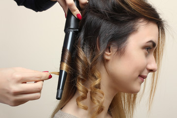 Hairdresser makes hair beautiful girl.