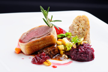 Roast duck, red cabbage roll and dry fruits in fine dining restaurant